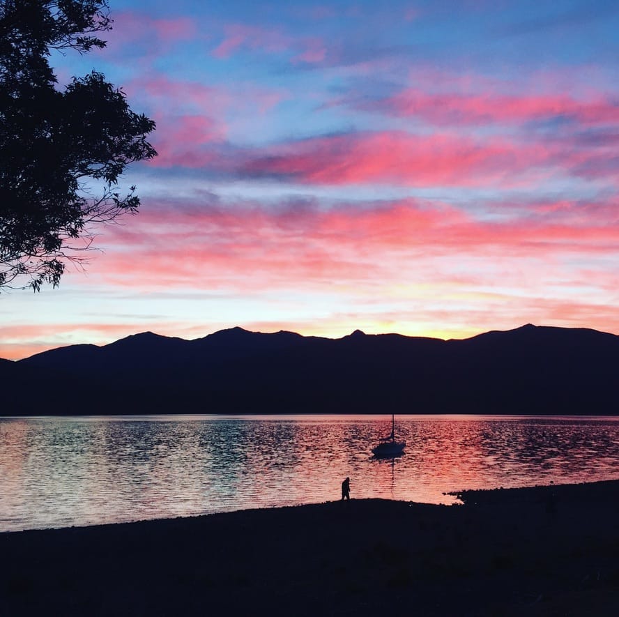 ED4D75BF-1E84-4A42-81EB-9FA9943F8A52_1_105_c View of Te Anau Lake in New Zealand at sunset.
